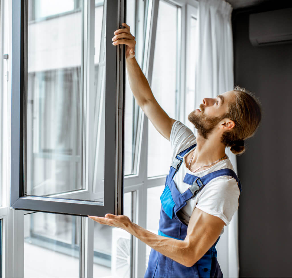 Man adjusting window frames